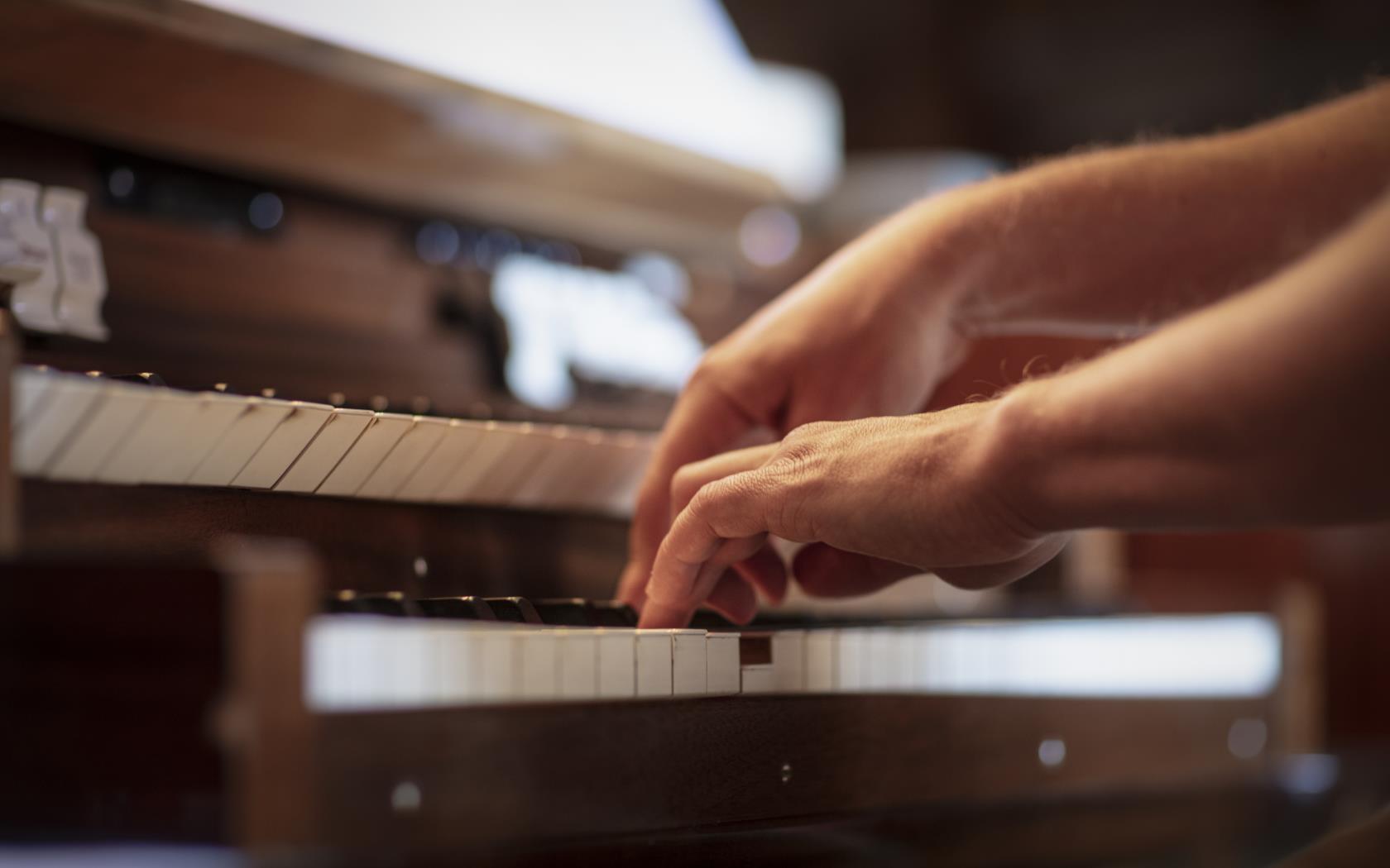 Närbild på någon som spelar orgel.