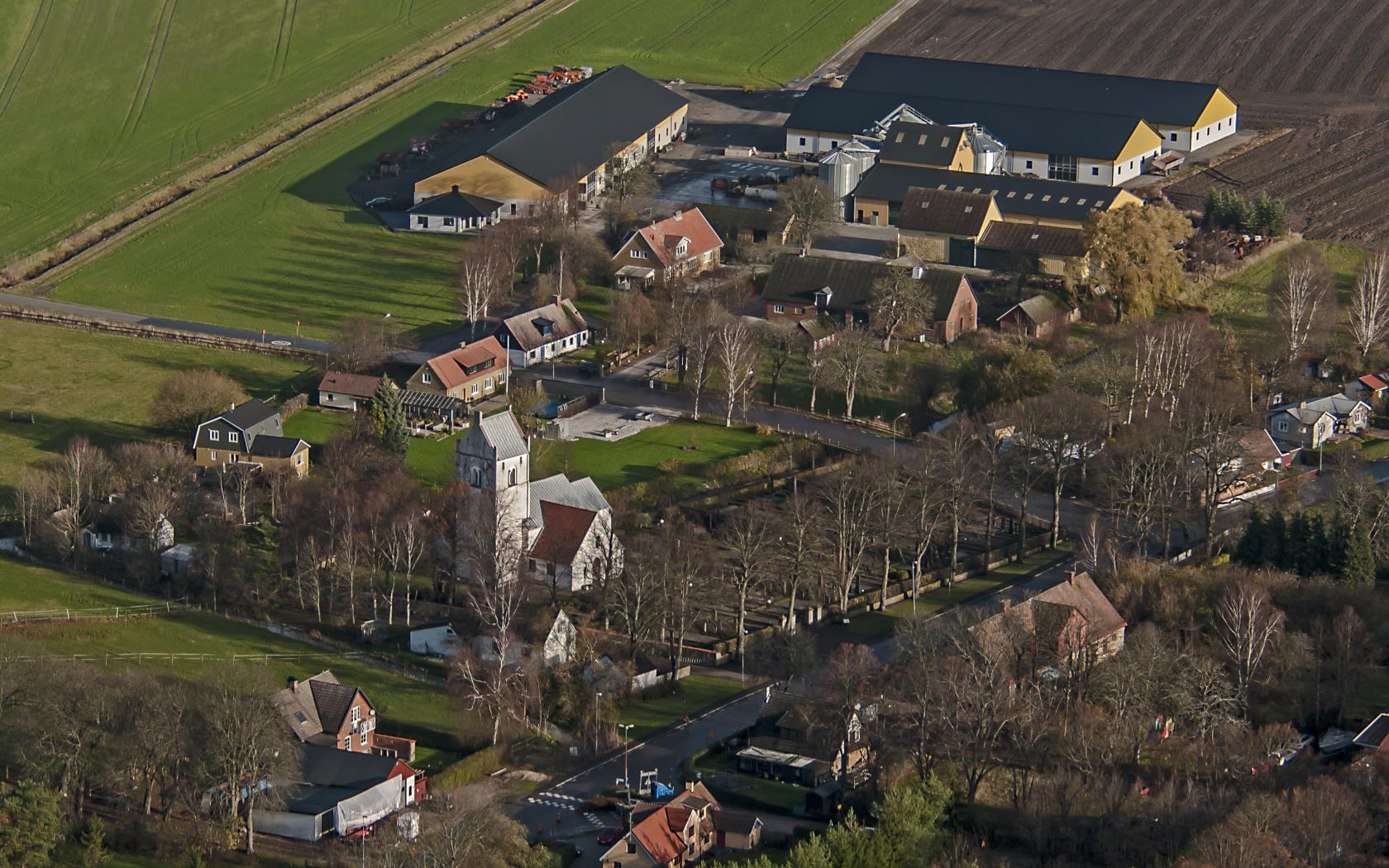 Vitkalkad kyrka med grått tak.