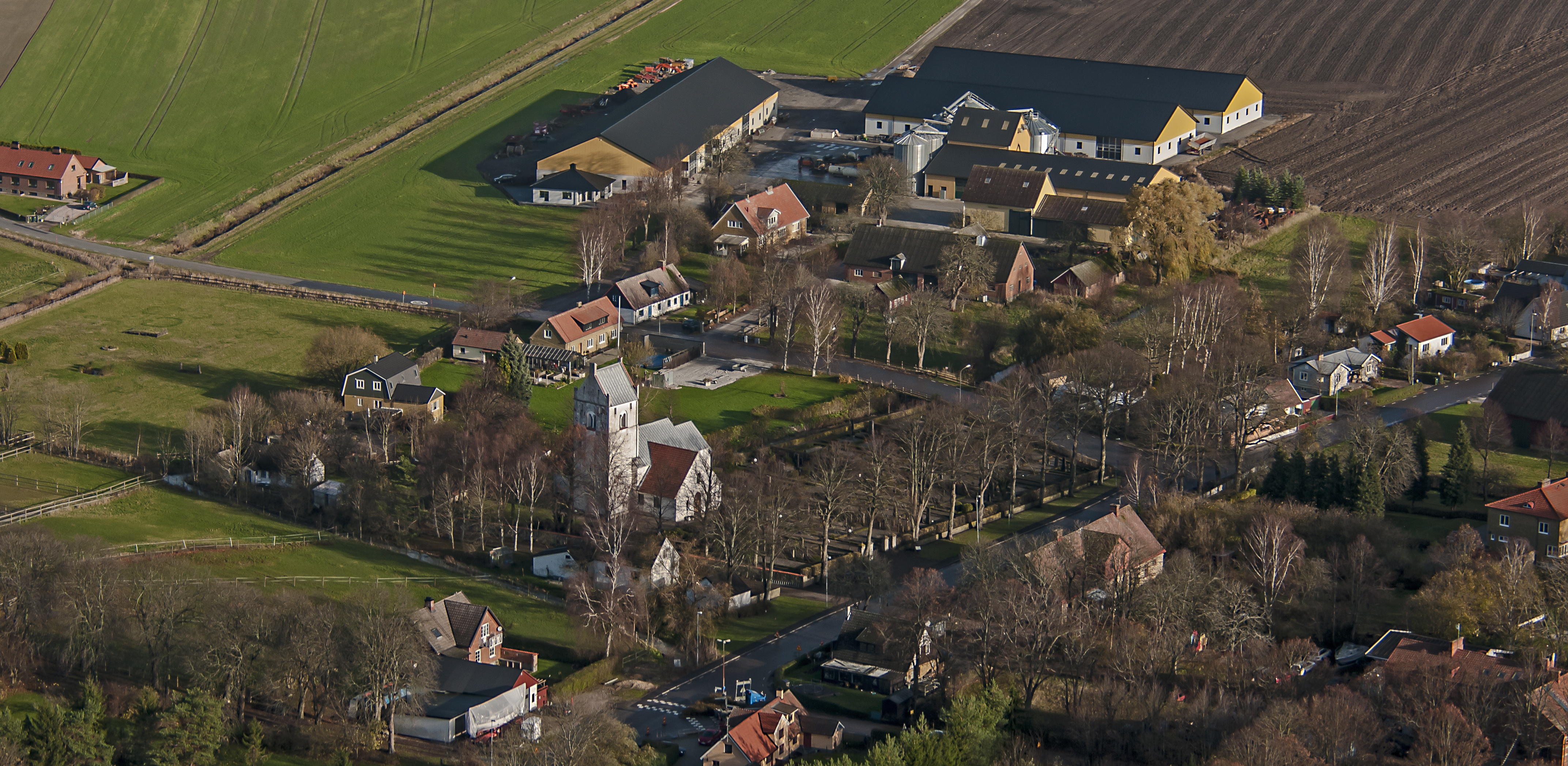 Vitkalkad kyrka med grått tak.