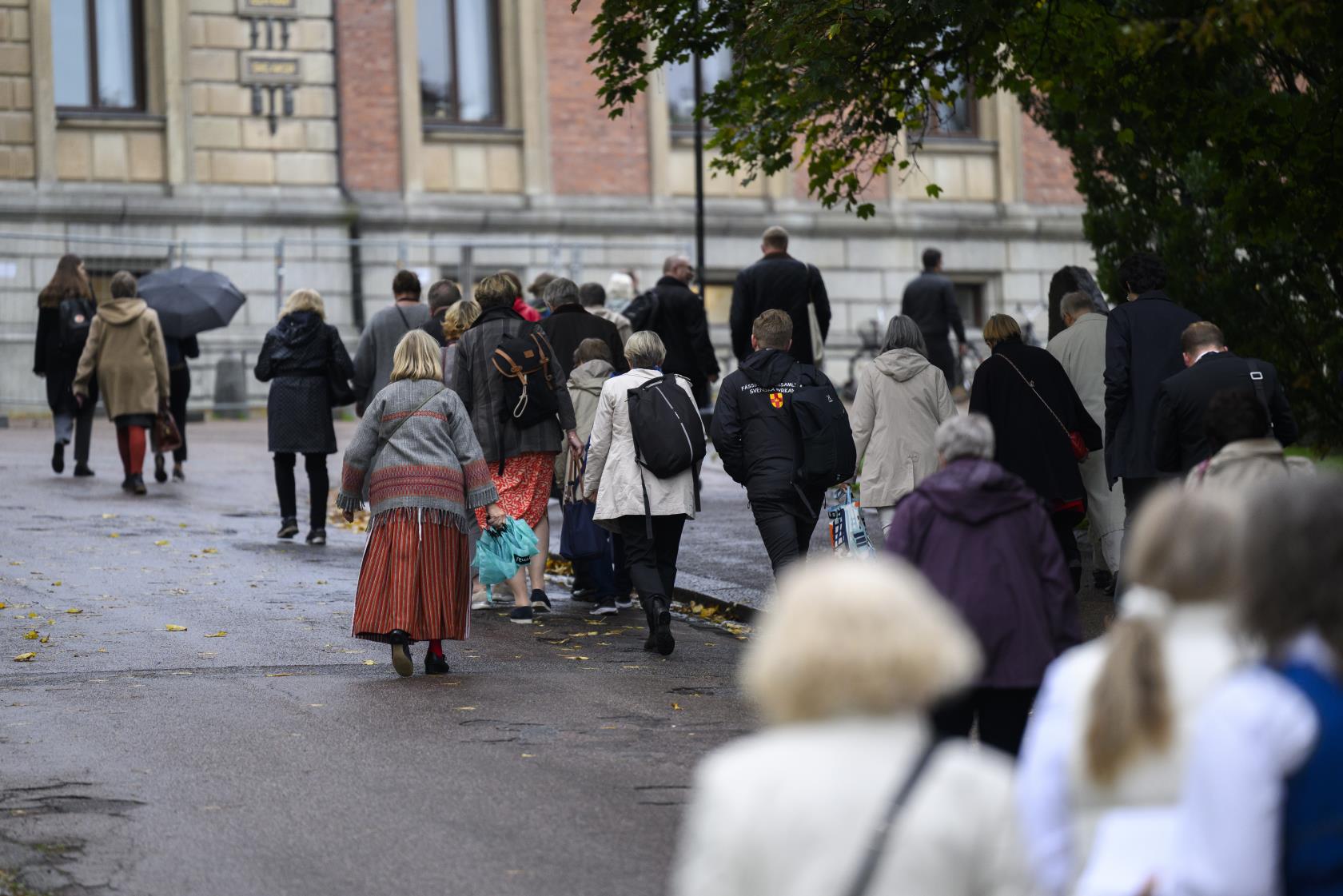 En stor grupp människor är på väg upp till Uppsala universitetshuset.