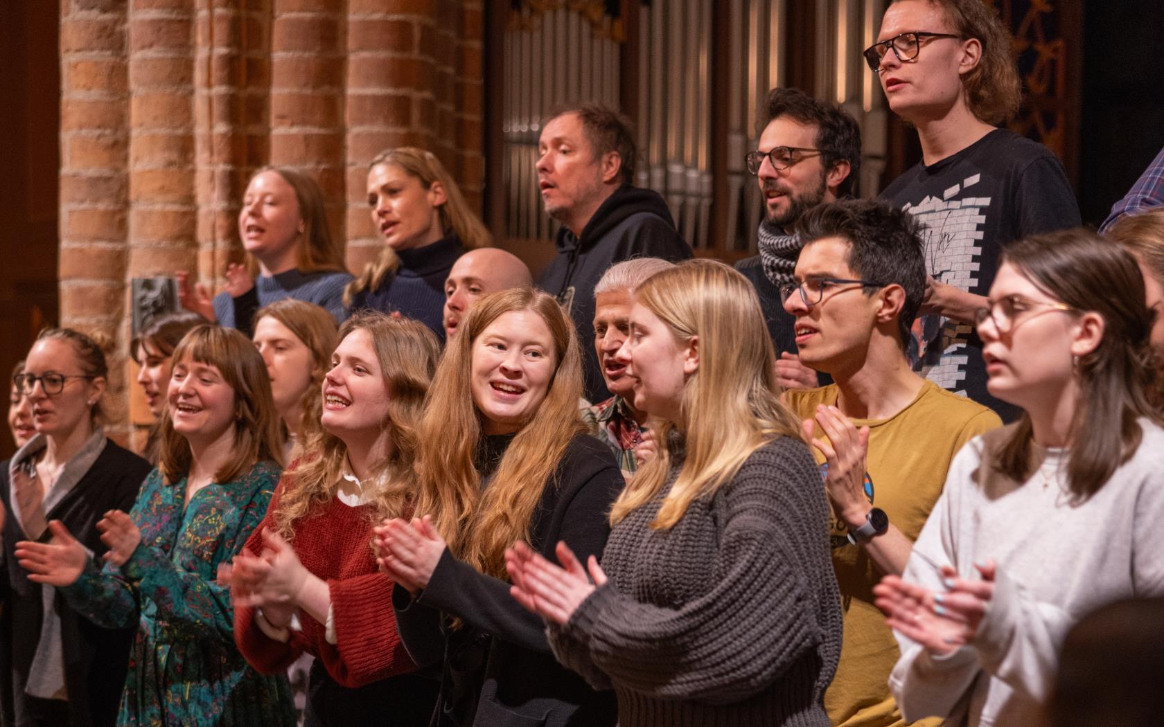 En blandad kör övar i en kyrka.