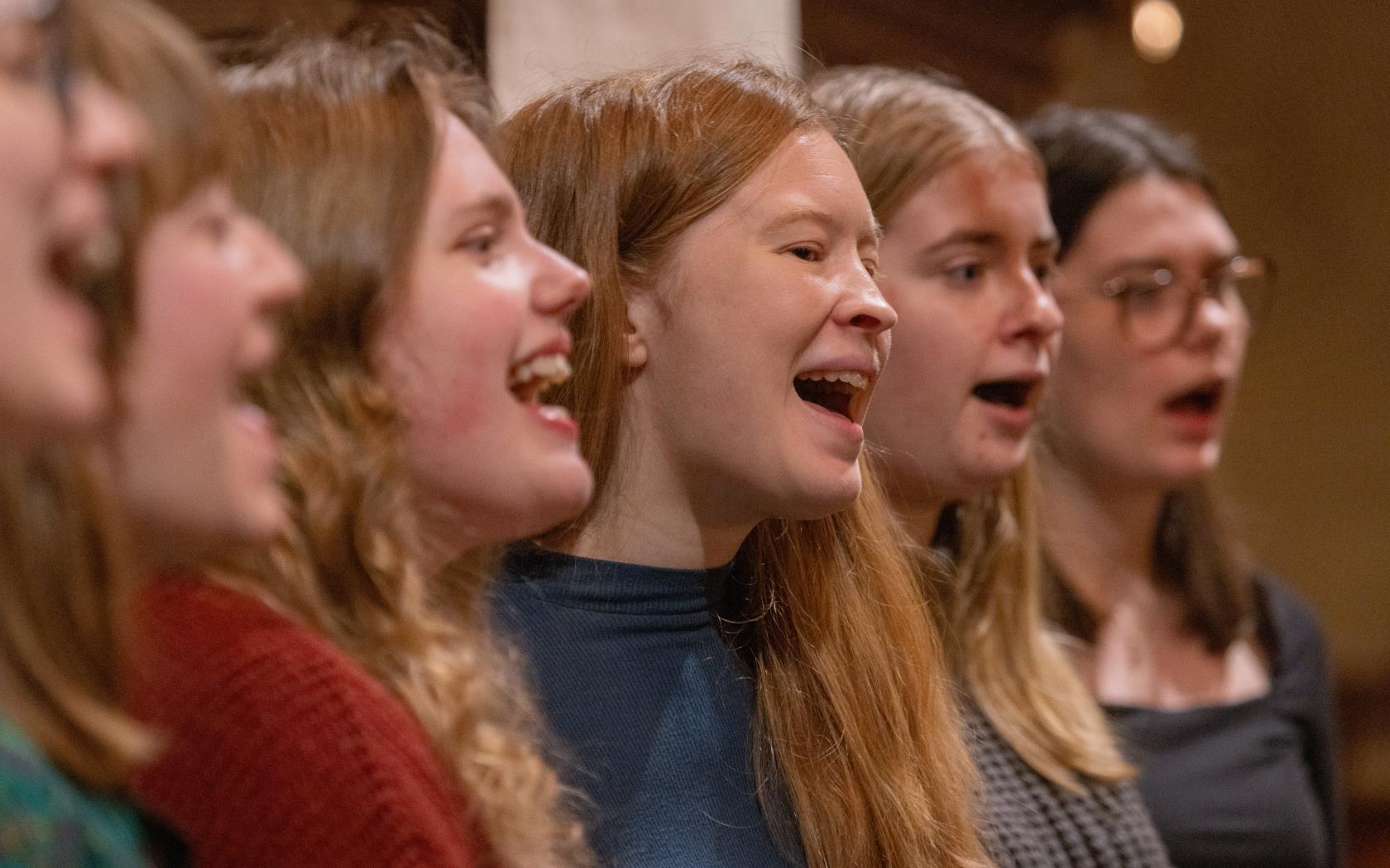 En blandad kör övar i en kyrka.