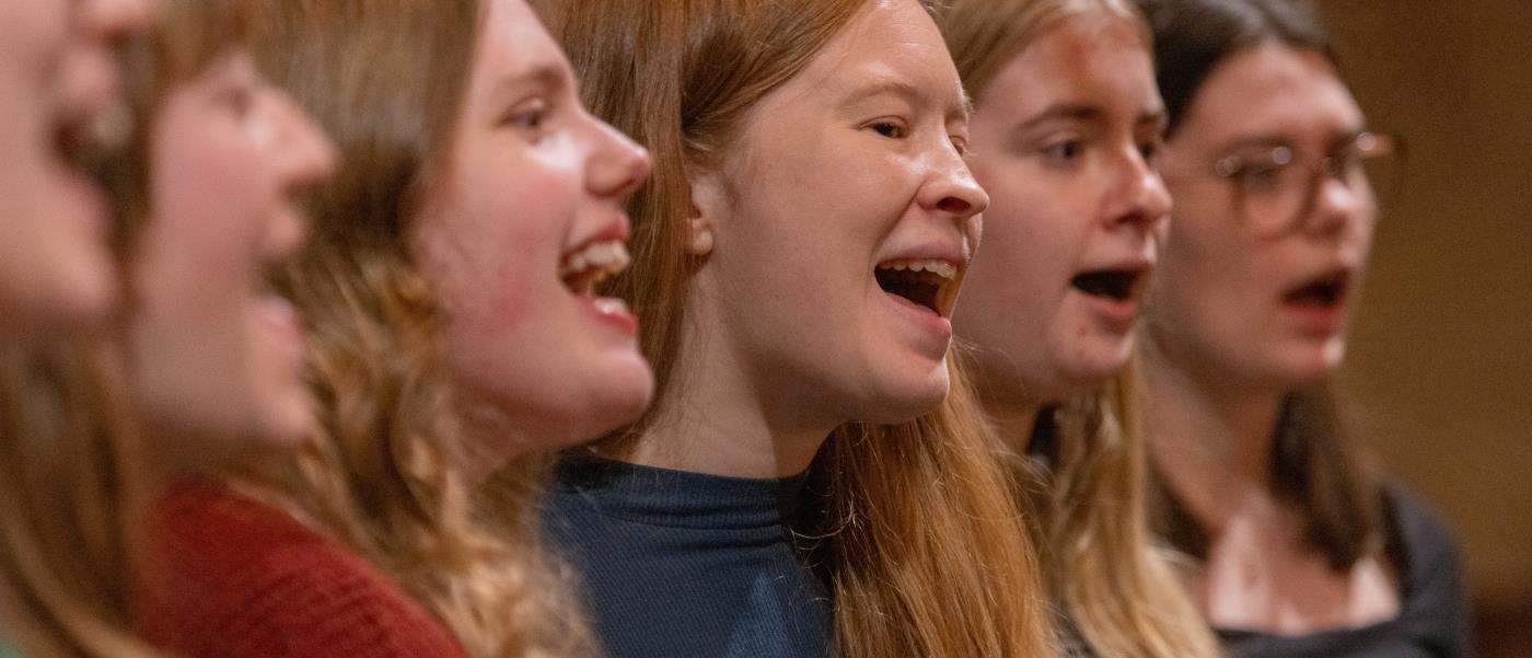 En blandad kör övar i en kyrka.