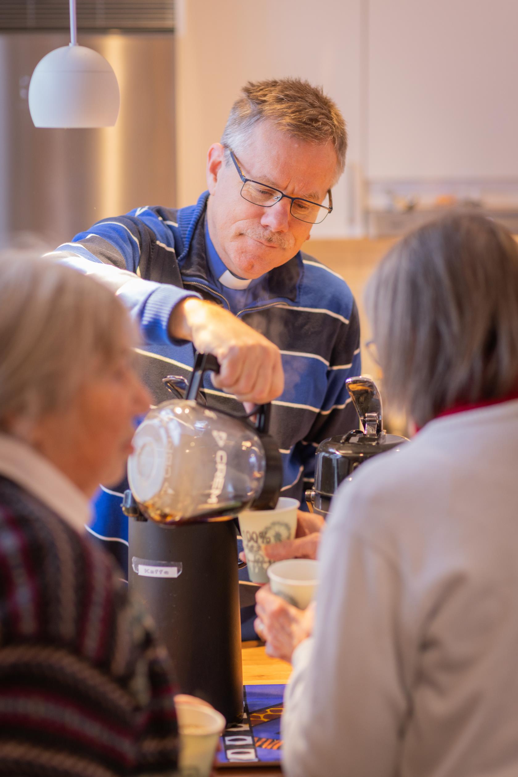 En man häller upp kaffe till en kvinna.