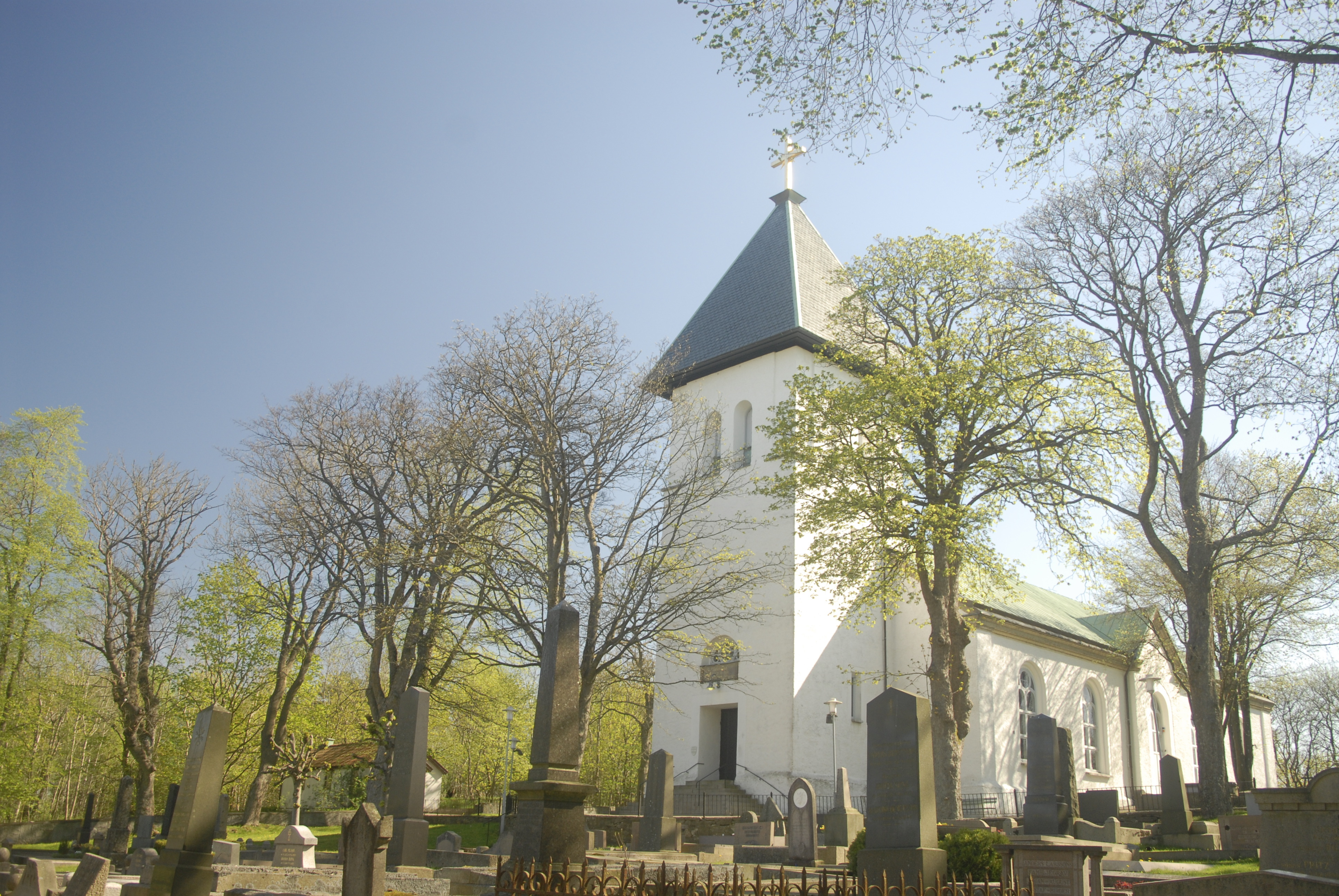 Backa kyrka i blommande grönska.