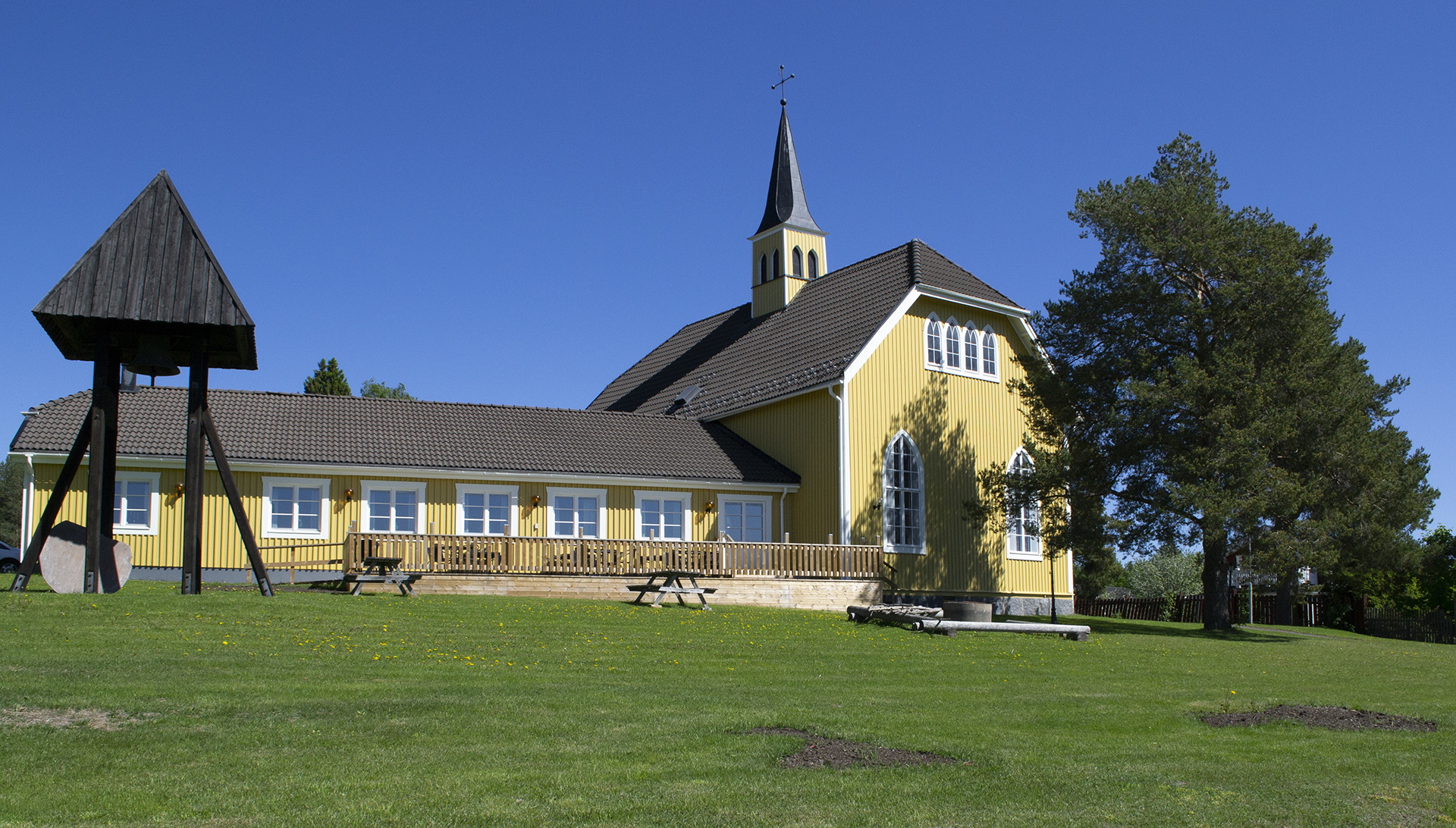 Bilden visar Ersmarks kyrka i Ersmark/Kågedalen. Kyrkan är byggd i trä och gulmålad.  Bilden är tagen på sommarhalvåret. 