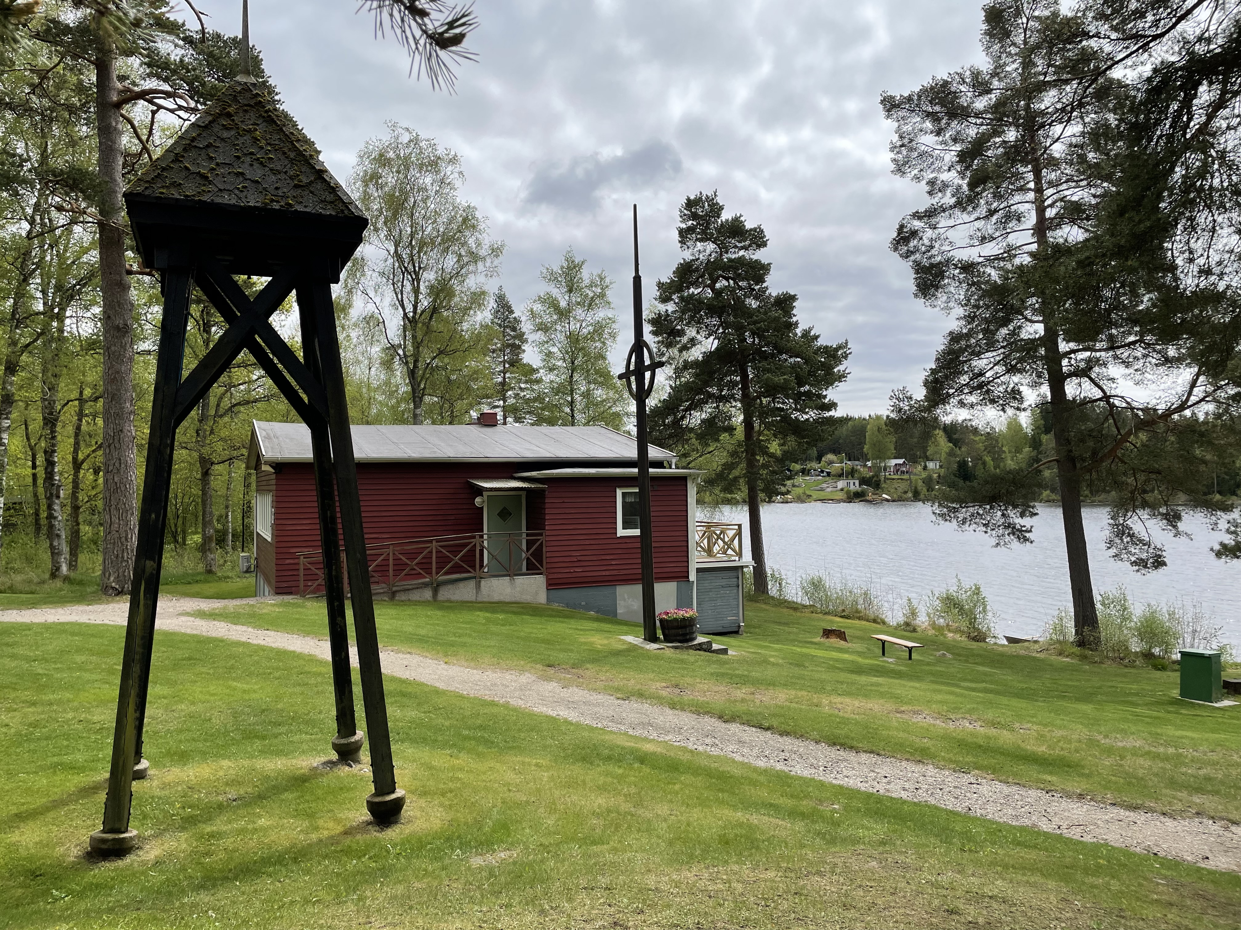 Röd träbyggnad vid strandkant.