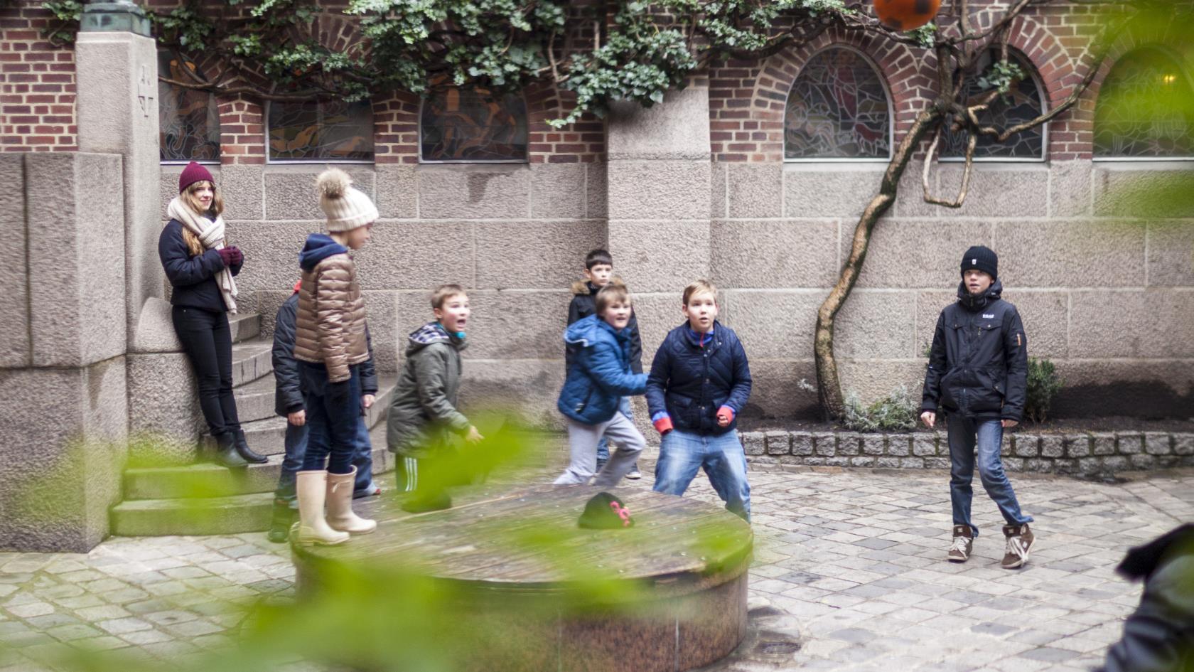 Barn som spelar boll på en skolgård.