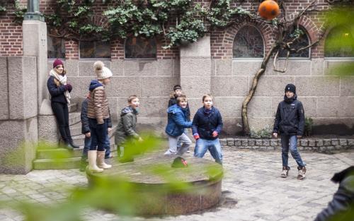 Barn som spelar boll på en skolgård.