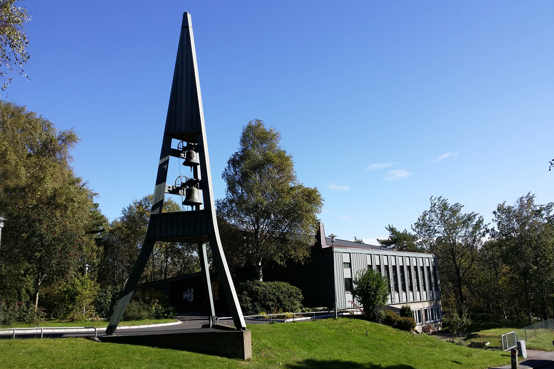 Den spetsiga klockstapeln i trä utanför Kaverös kyrka.