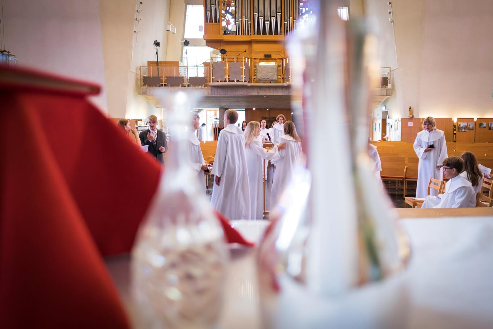 Konfirmander i en kyrka, med kyrkorgeln i bakgrunden