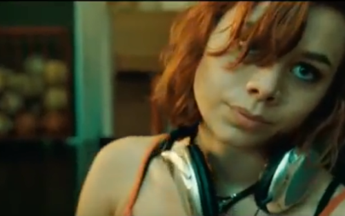 Scen från filmen Vegas. Rödhårig tjej med stora hörlurar.